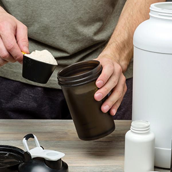 man with shaker and scoop of promiko powder