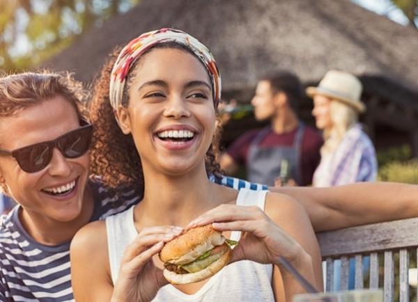 image of a couple eating a burger at a bbq