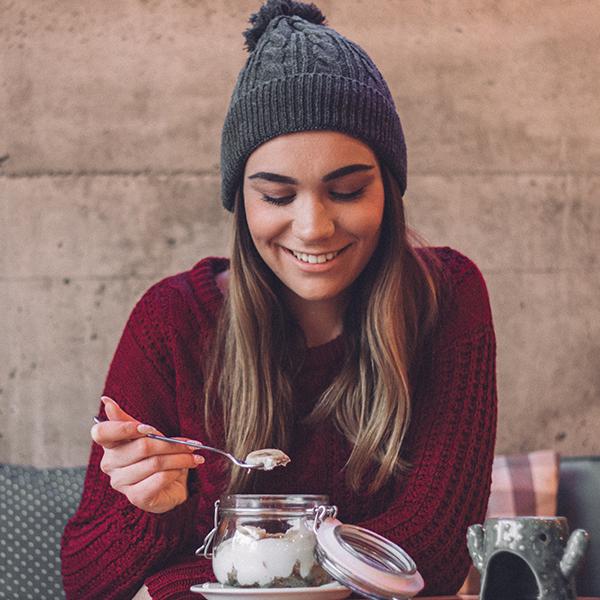 image of a woman eating a yoghurt