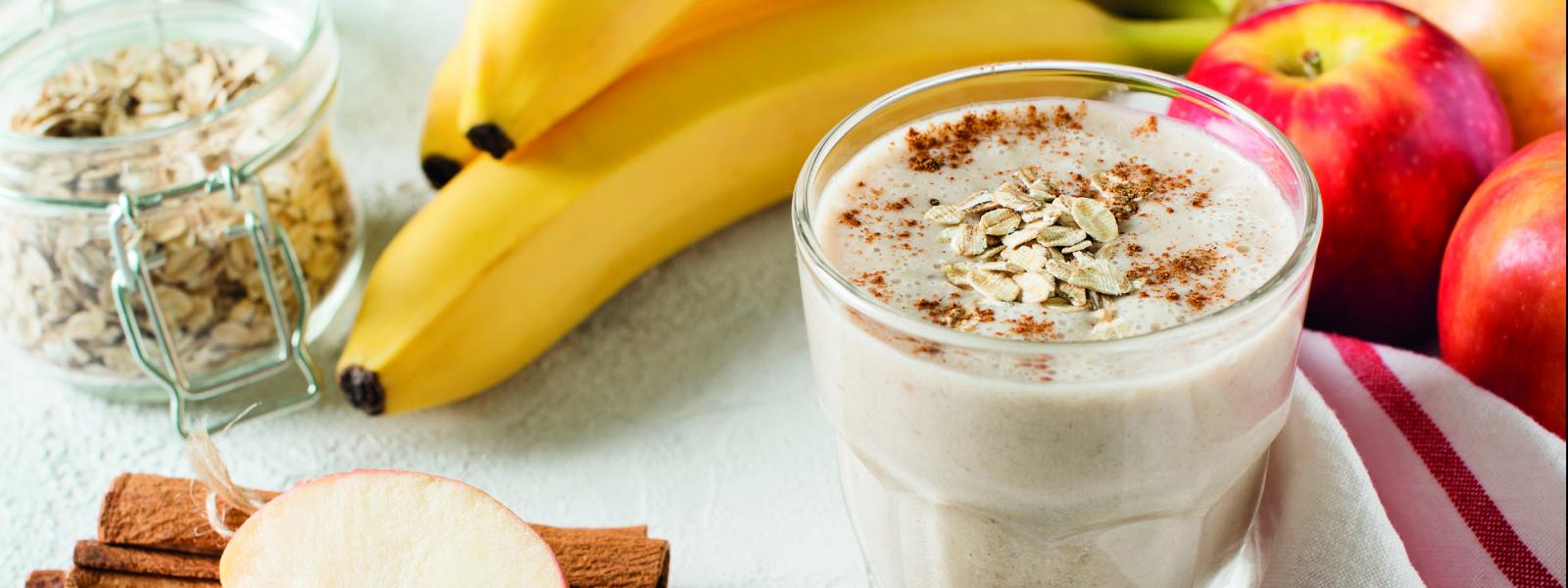 Static image featuring two bananas as well as the feature: a small bowl of porridge topped with oats.